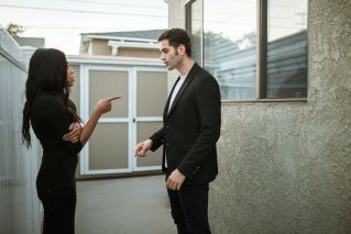 Man in Black Suit Standing Beside Woman in Black Dress